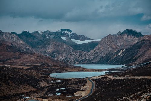 Free A captivating view of rugged mountains and a tranquil lake under an overcast sky. Stock Photo