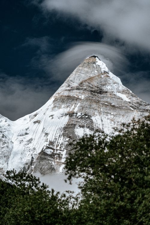 Free Stunning view of a snow-covered mountain peak against a dramatic sky. Stock Photo