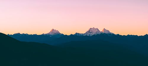 Free Beautiful mountain range silhouette at sunrise with a pastel sky. Stock Photo