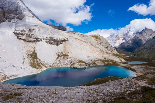 Free Stunning mountain landscape featuring a vibrant blue lake surrounded by rugged peaks and clear skies. Stock Photo