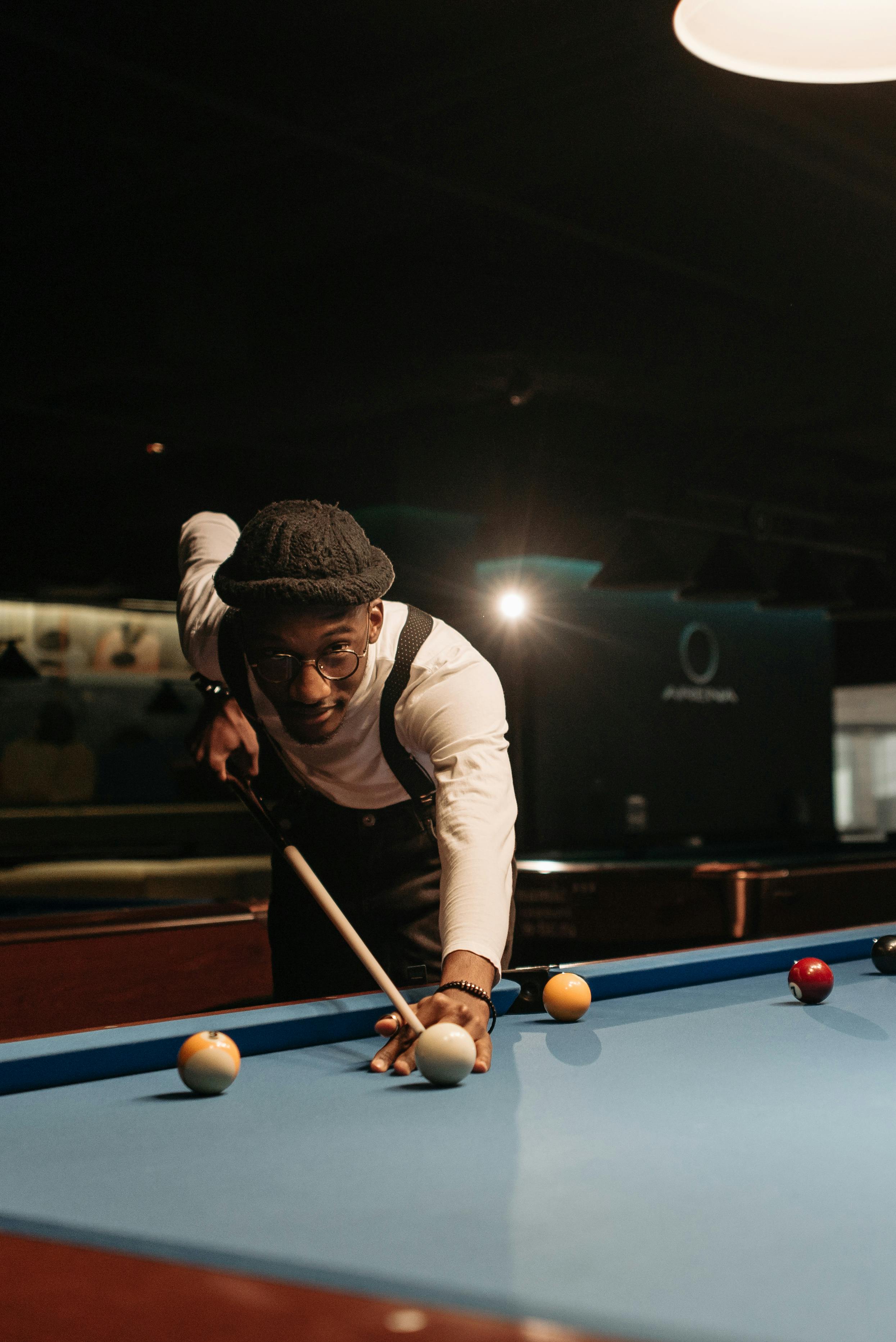 man in white long sleeves playing billiard