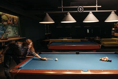 Woman Hitting the Ball with Cue Stick