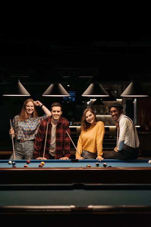 Group of young friends playing billiard 945174 Stock Photo at Vecteezy
