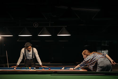 A Man and a Woman Playing Billiard in a Hall