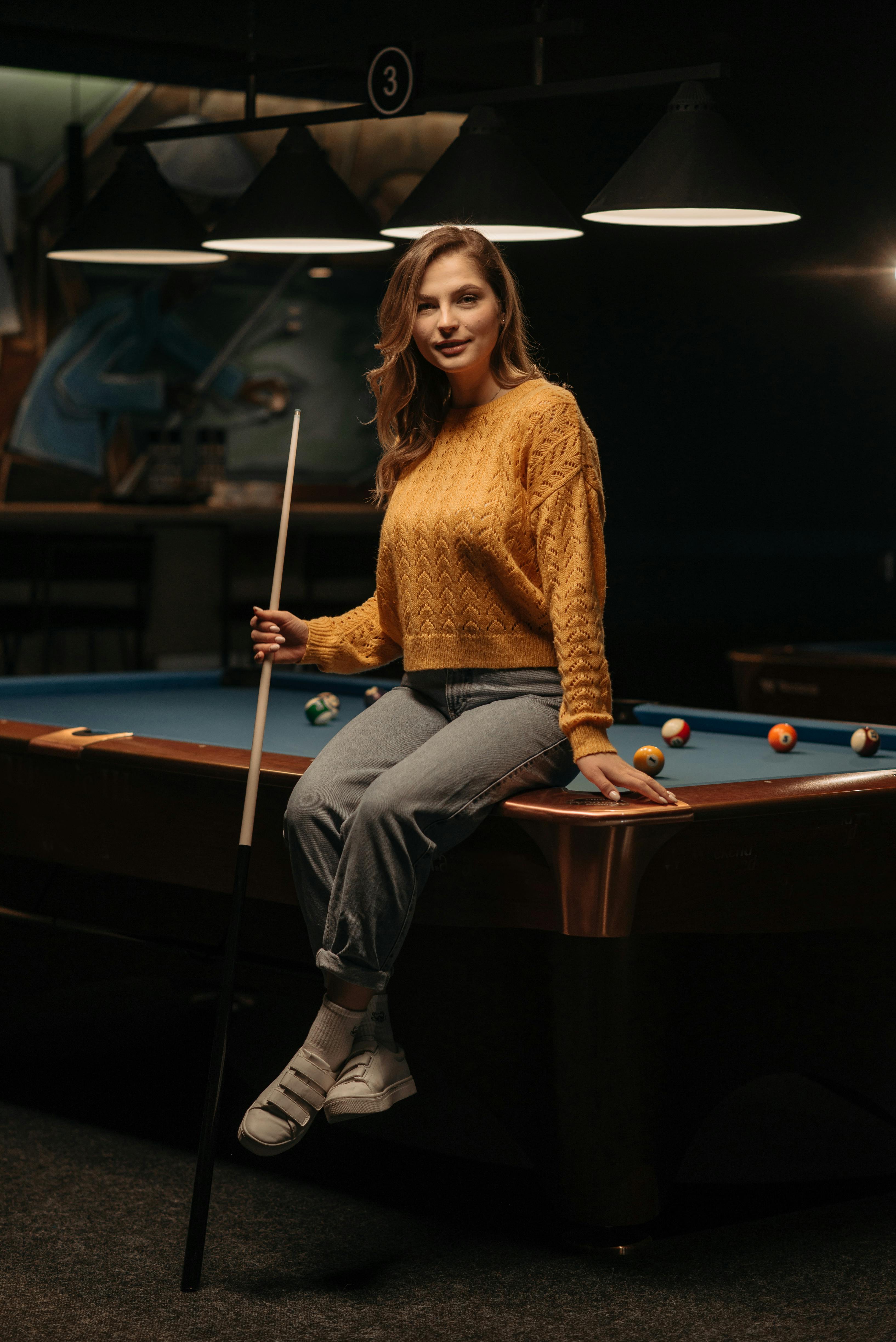 woman sitting on billiard table