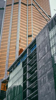 Low angle view of contemporary skyscrapers with reflective glass and concrete structures.
