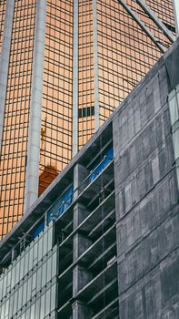 A striking low-angle view of modern skyscraper architecture with reflective surfaces and bold geometric lines.