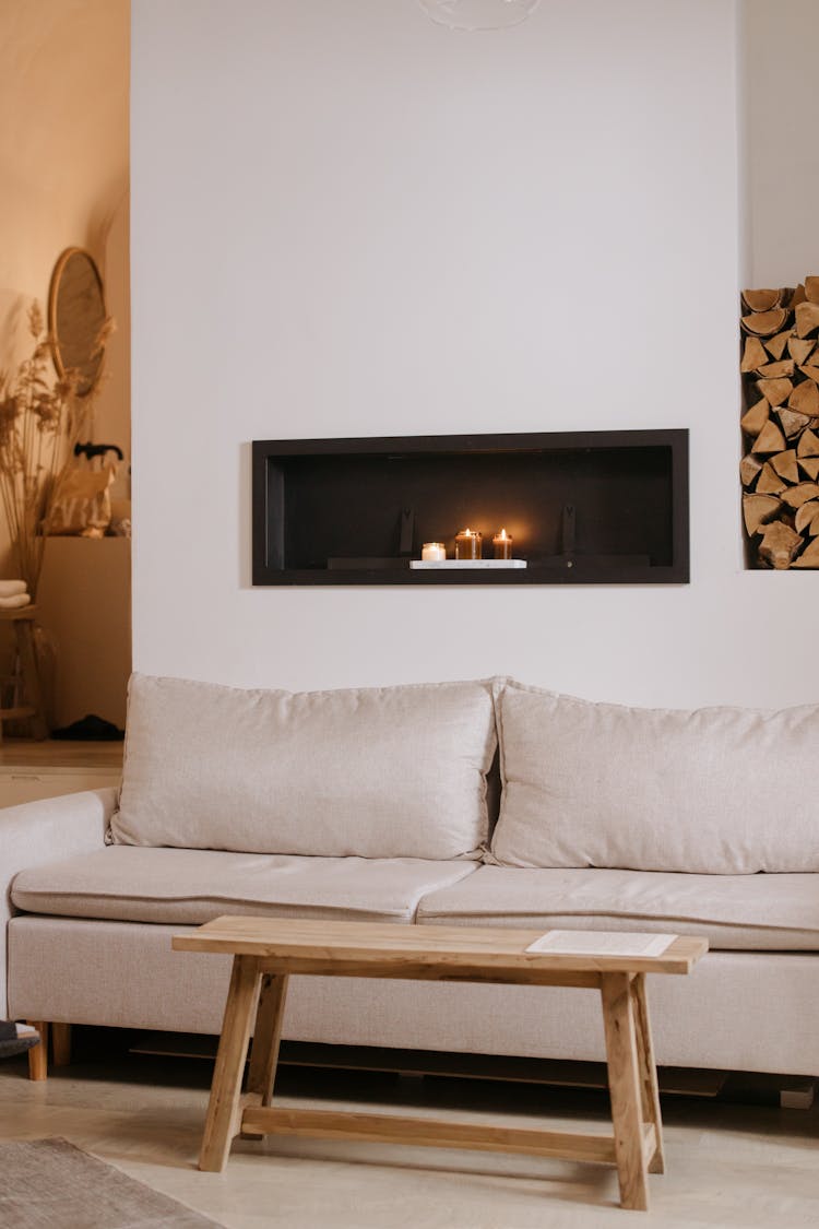 A Cozy Couch With Pillows Near The Wooden Table