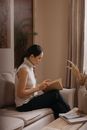 Woman in White Tank Top Sitting on White Sofa