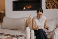 Woman in White Tank Top Sitting on White Couch