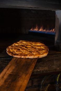Warm pita bread with sesame seeds baking in a traditional Turkish oven, showcasing rustic culinary art.