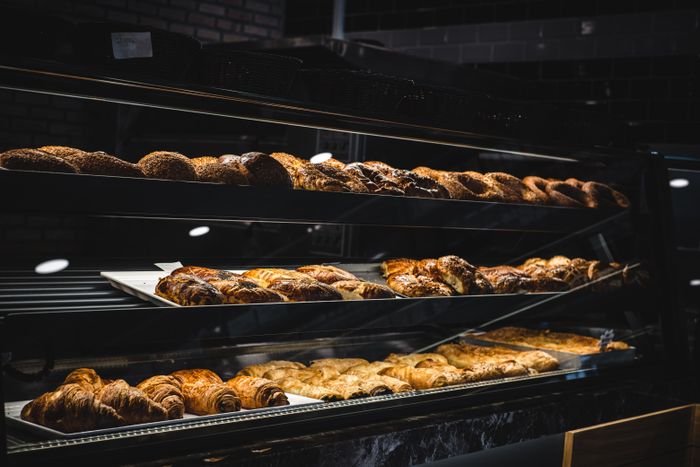 Trays of pastries cooling on bakery racks — photo by Furkan Tumer on Pexels