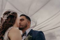 Ethnic groom kissing unrecognizable bride on wedding day