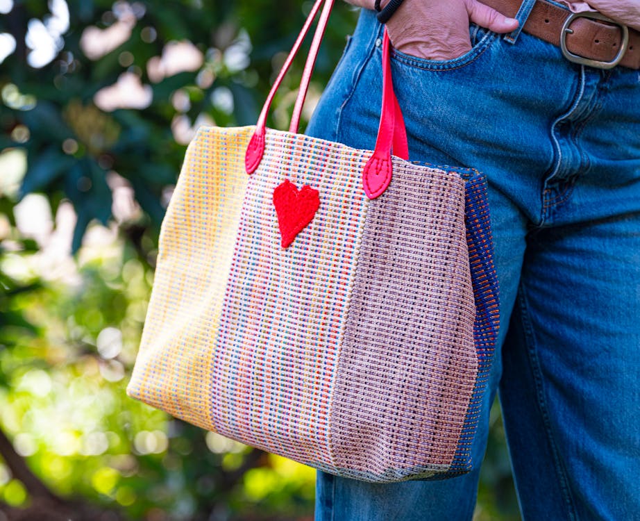 Free Close-up of a stylish woven tote bag with a heart shape outdoors. Stock Photo
