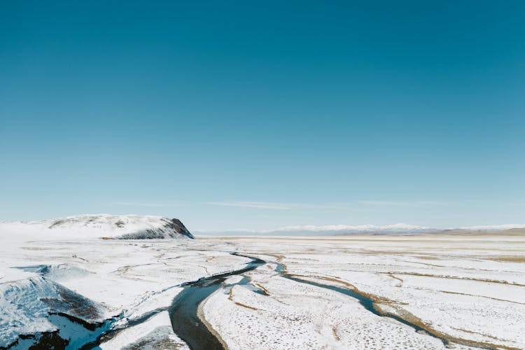 Aerial Shot Of A River In The Snow Covered Valley