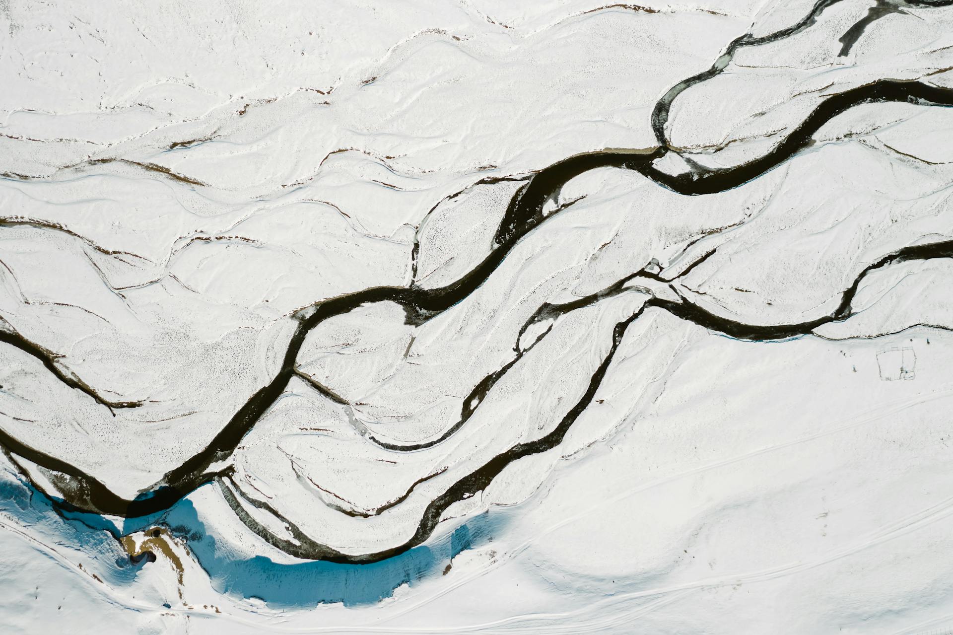 Scenic aerial view of a winding river in snow-covered Russian landscape, showcasing winter beauty.