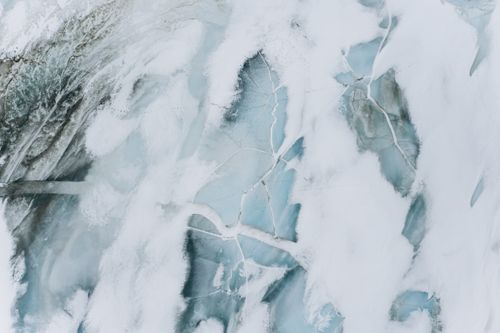 Free Stunning aerial view of abstract cracked ice patterns on a frozen surface in winter. Stock Photo
