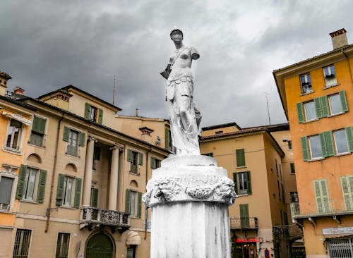 Statue of Man Near Brown Building