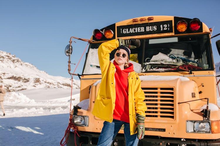 Woman In Winter Clothing Standing In Front Of A School Bus