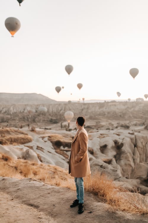 bezplatná Základová fotografie zdarma na téma cappadocia, hnědý kabát, horkovzdušné balóny Základová fotografie