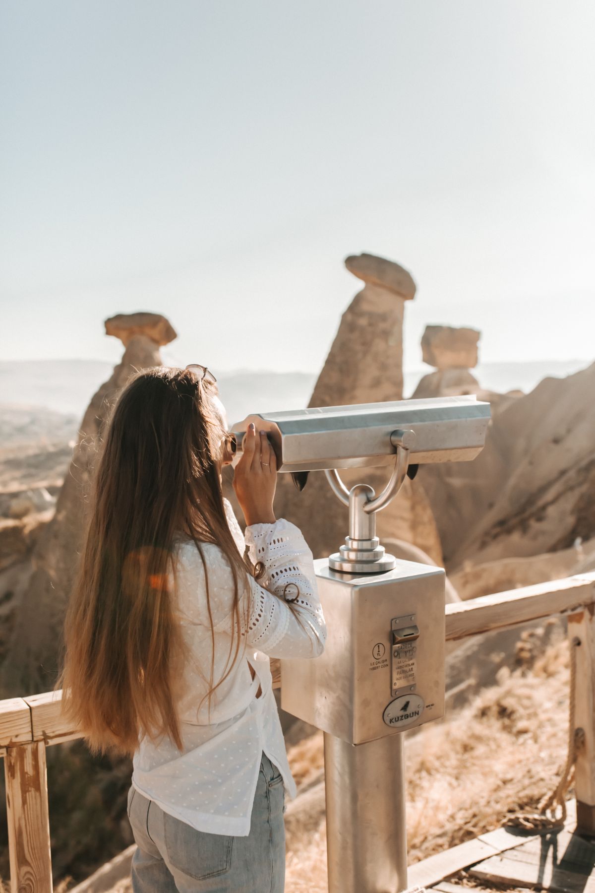 Woman looking through binoculars over a city skyline, watching from a high vantage point