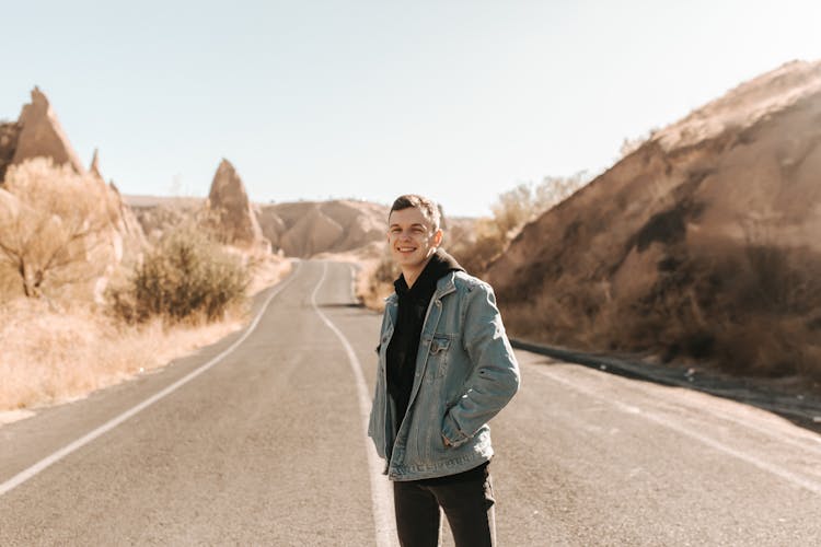 A Young Man Standing In The Middle Of A Road  