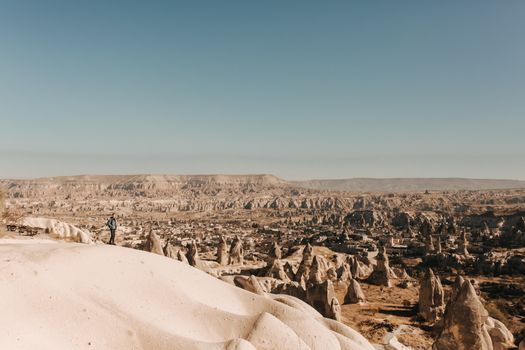 Explore the stunning landscape of Cappadocia with its unique rock formations under a clear sky.