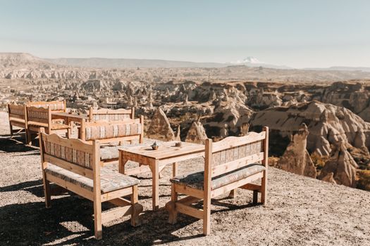 Explore the breathtaking landscape of Cappadocia with outdoor seating overlooking unique rock formations.