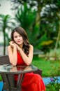 Woman Wearing Red Dress Posing Outdoors