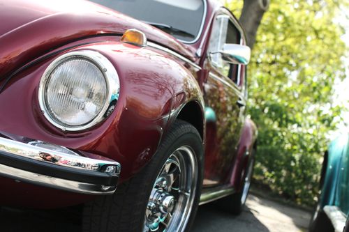 Free Close-up of a classic maroon beetle car in sunlight. Perfect for vintage car enthusiasts. Stock Photo