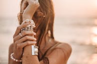 日落时分，一名女子在海滩上摆着时尚的珠宝