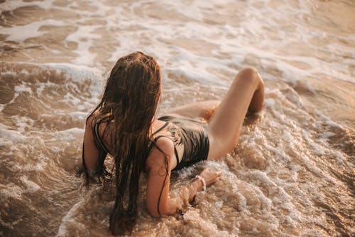 Free A Woman Lying Down on the Shore Stock Photo