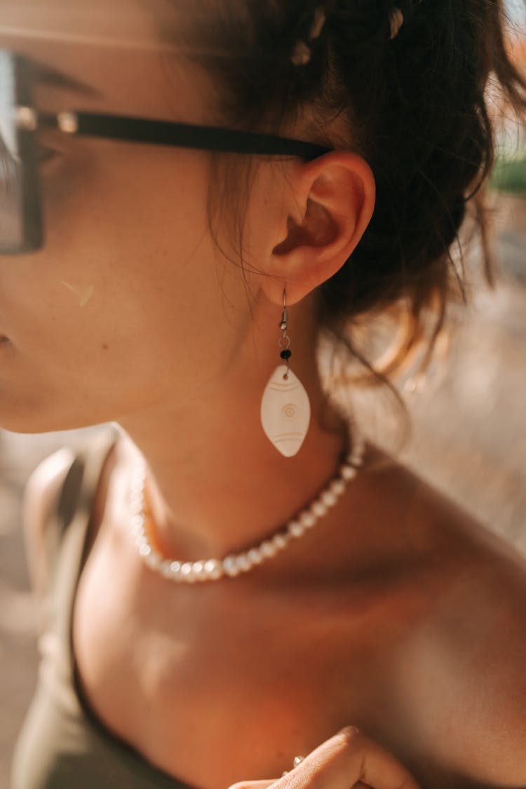 A Woman Wearing Accessories On Her Ear And Neck