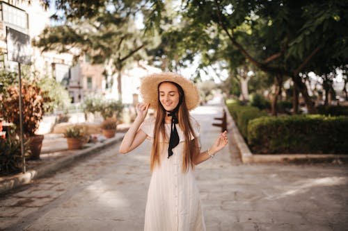 Pretty Woman in White Dress Wearing a Straw Hat