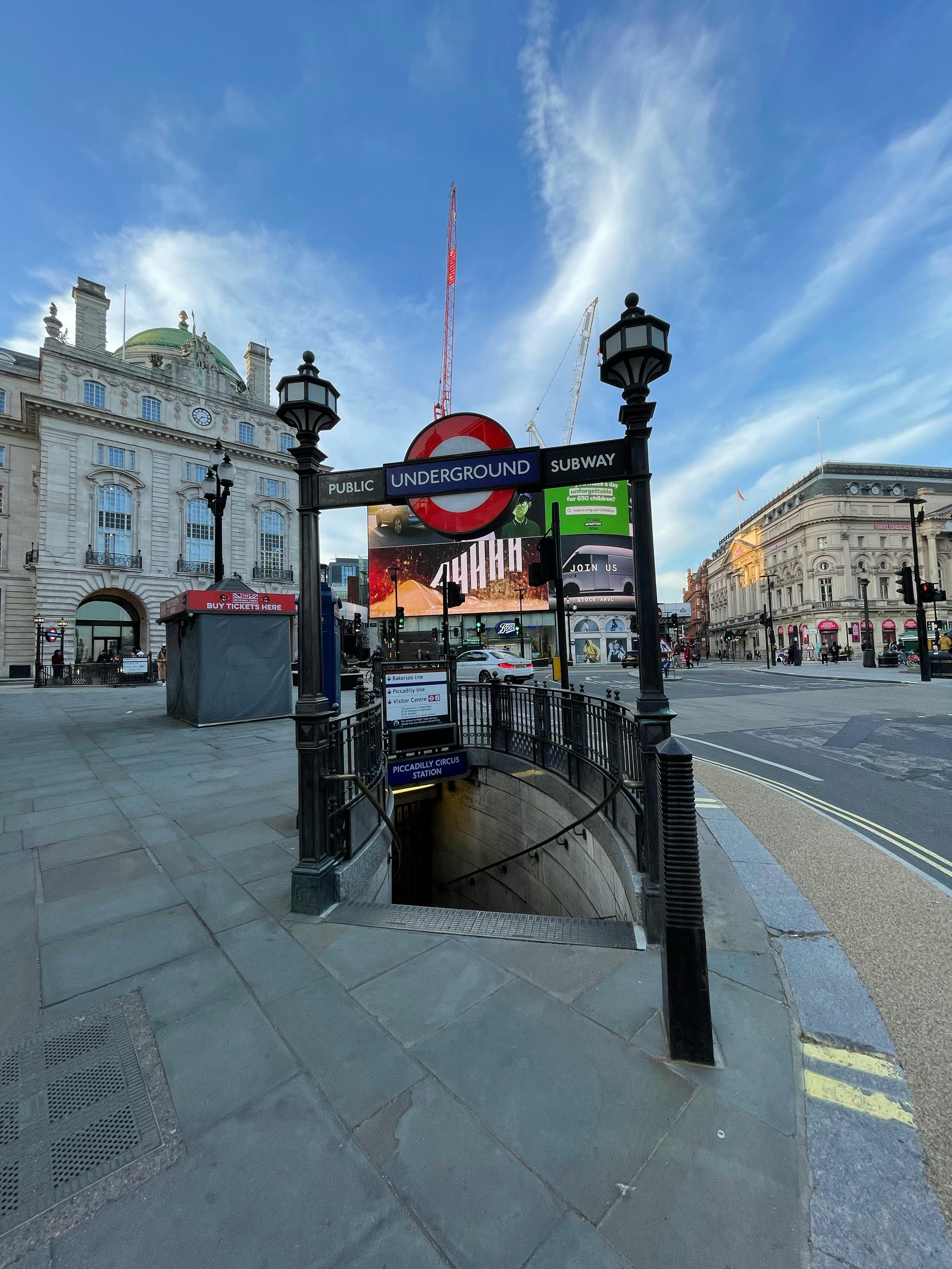 Free Entrance to London underground with lanterns on old street with classic buildings under blue sky Stock Photo