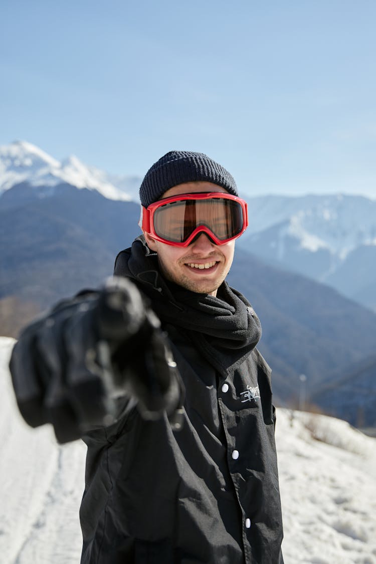 A Man Wearing Goggles Pointing His Finger