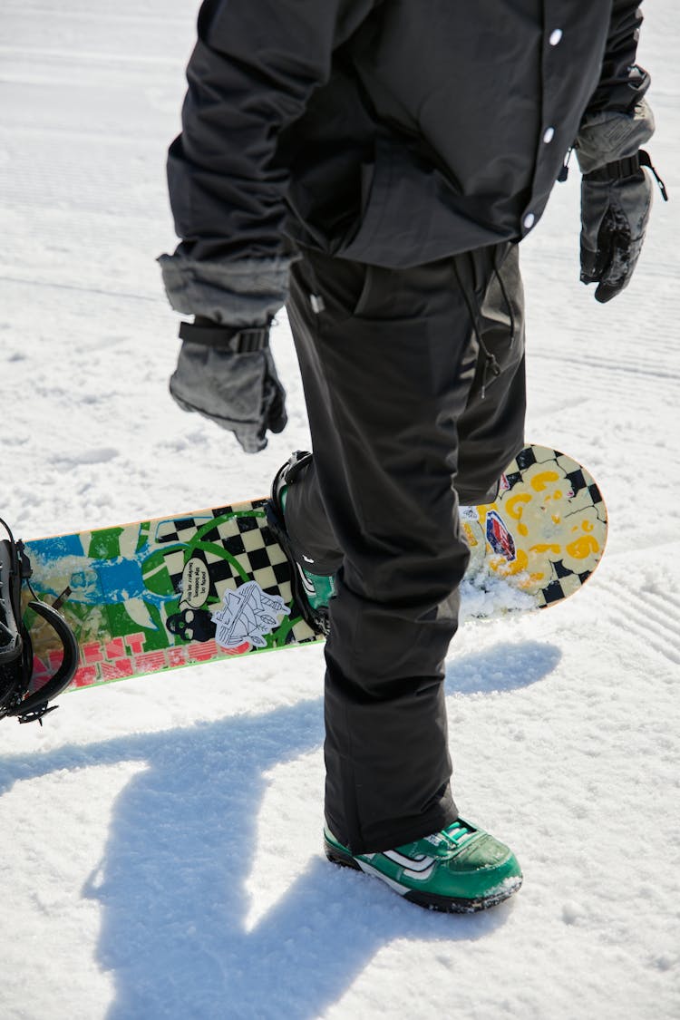 A Man Removing His Snowboard