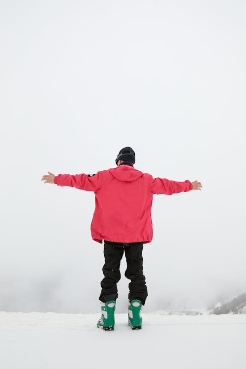 Free A Man Standing on the Edge and Spreading His Arms Stock Photo