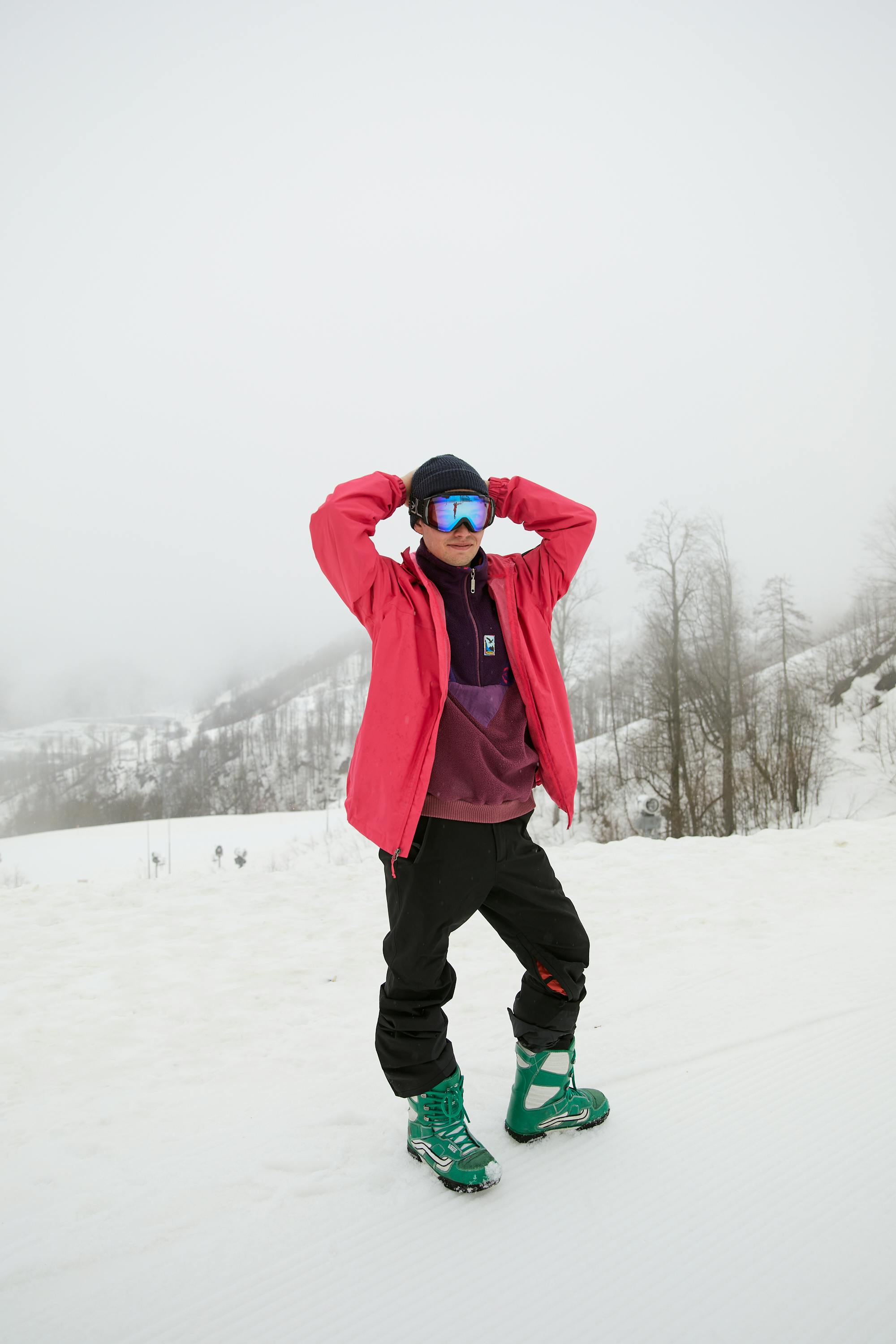 Prescription Goggle Inserts - Man in winter clothing posing on snowy slope with foggy background.