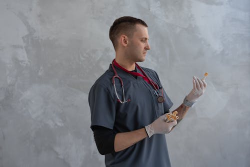 A Man in Scrub Suit Holding Specimen Test Tube