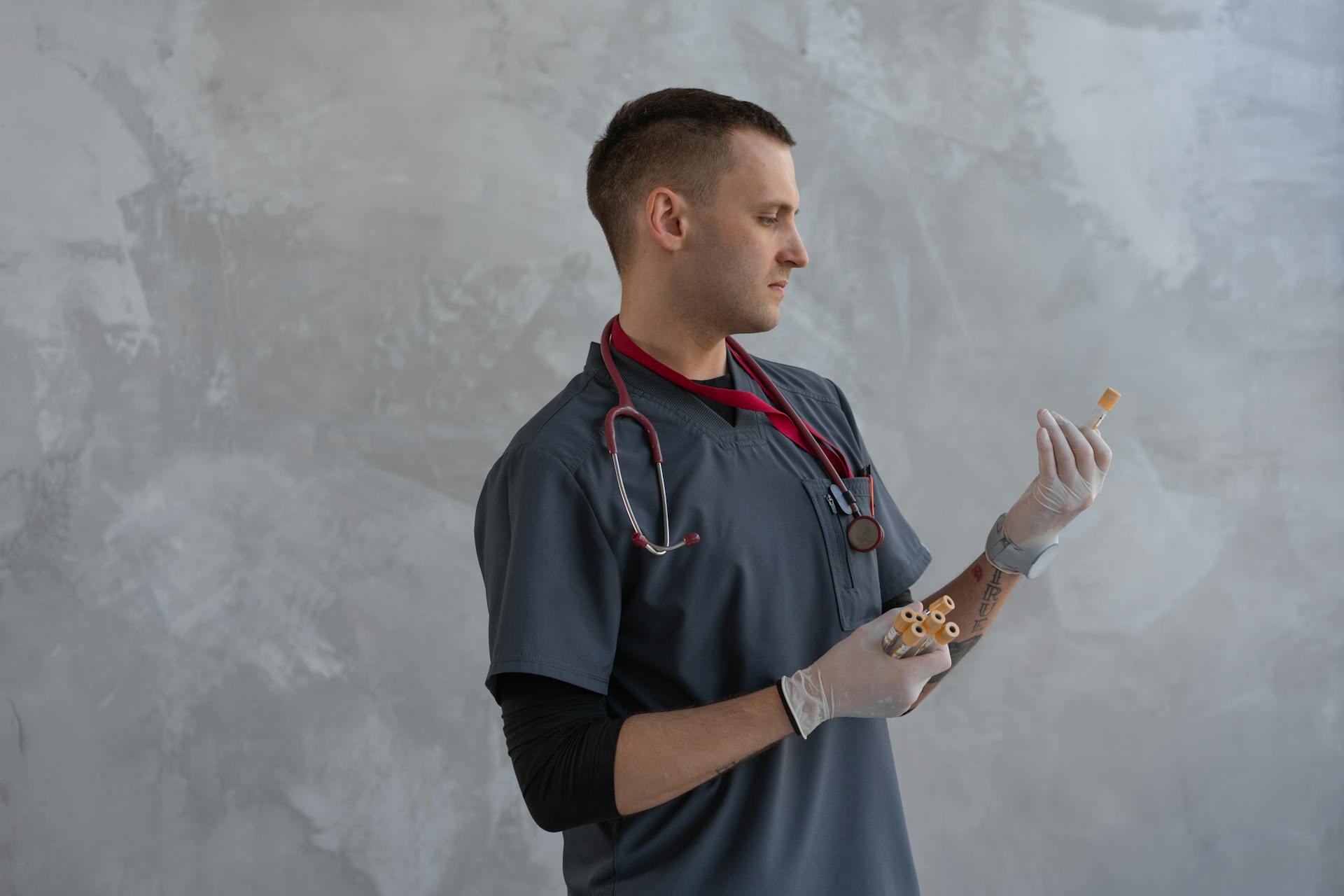 A Man in Scrub Suit Holding Specimen Test Tube