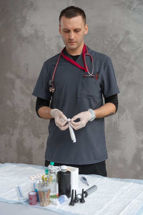 Man Wearing Gray Scrub Suit and Latex Gloves