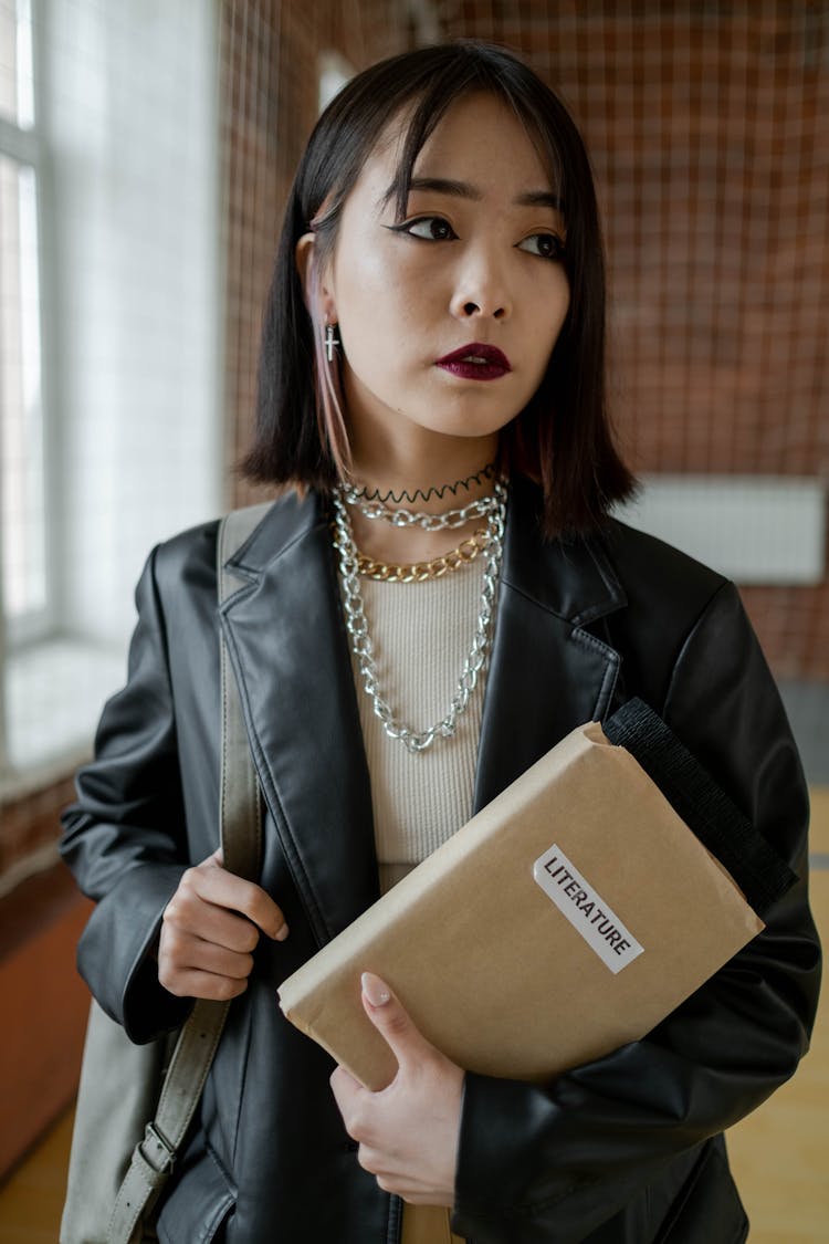 Girl In Black Leather Necklaces Holding A Book