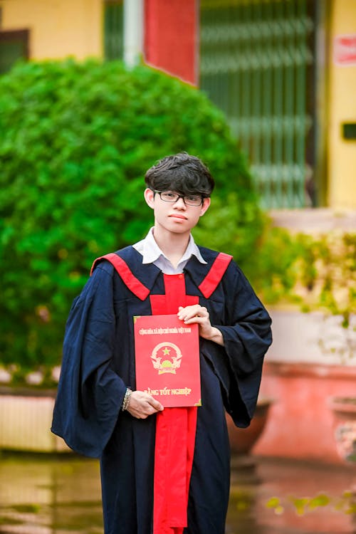 Free Man in Black Academic Dress Holding Red Paper Stock Photo