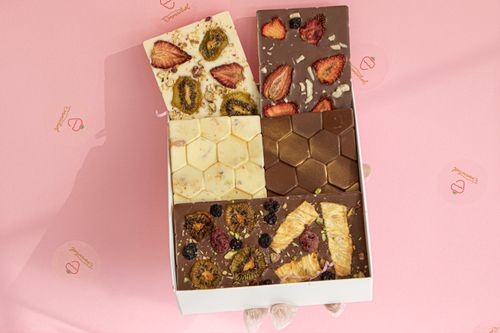Free Delicious assortment of gourmet chocolates topped with dried fruits in a box. Stock Photo