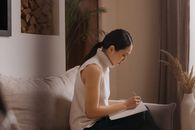 Woman in White Tank Top Sitting on Couch