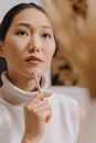 Woman in White Turtleneck Sweater Holding Pen