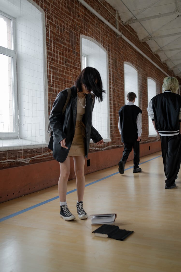 Student Looking At Her Books On The Floor