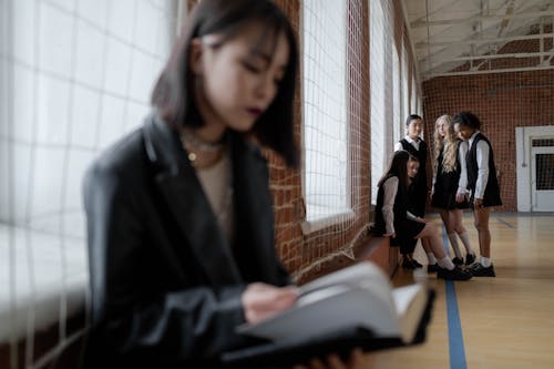 Woman in Black Leather Jacket Reading a Book 