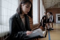 Woman in Black Blazer Sitting by the Table